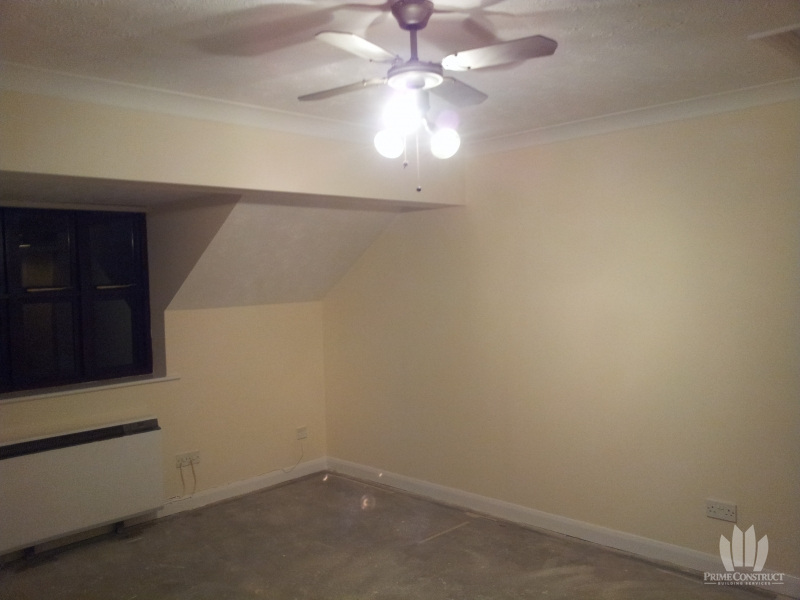 Decorated studio room with ceiling fan and sloping wall