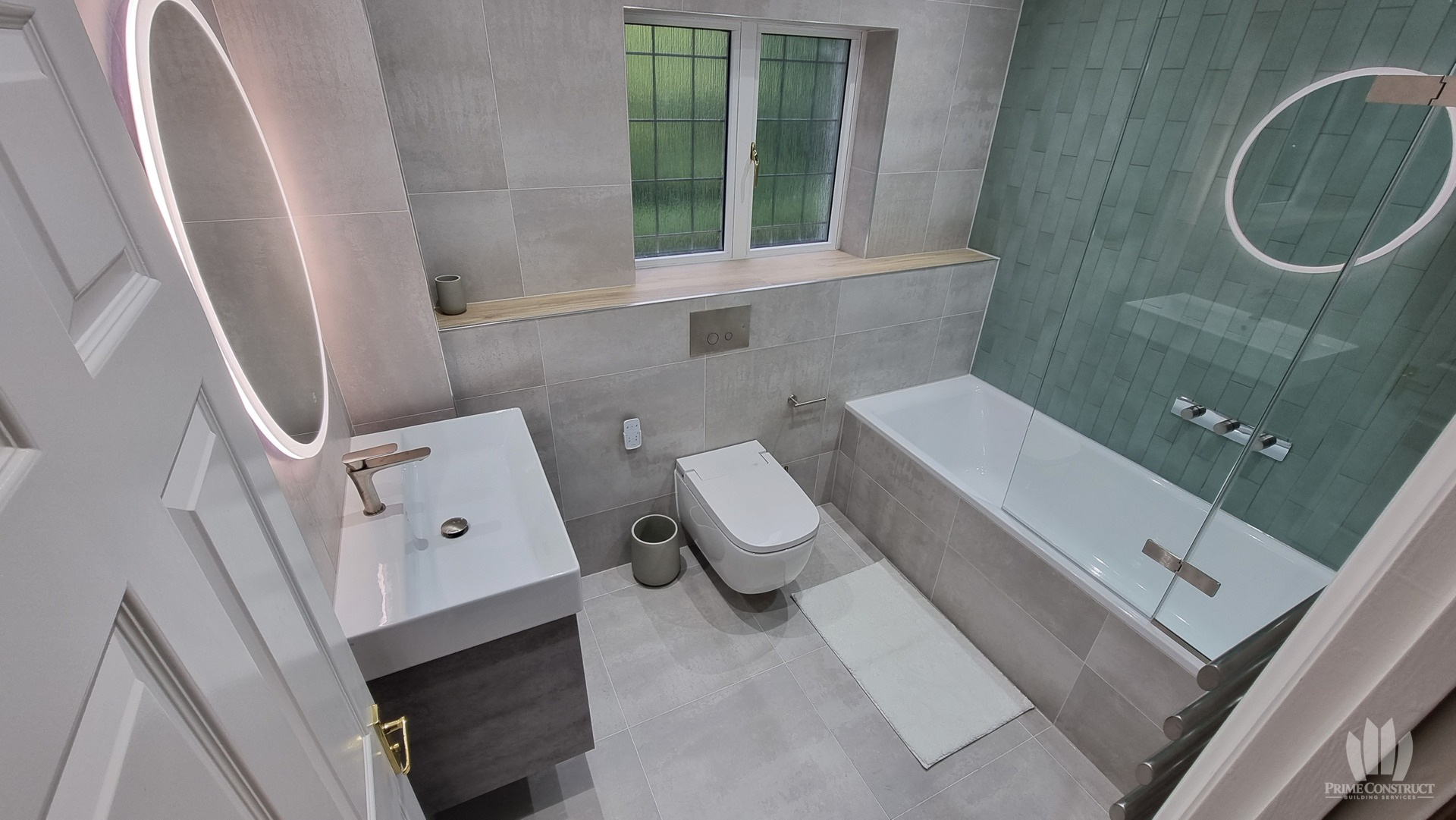 Master bathroom wide view including vanity, WC, bath and green tiled wall
