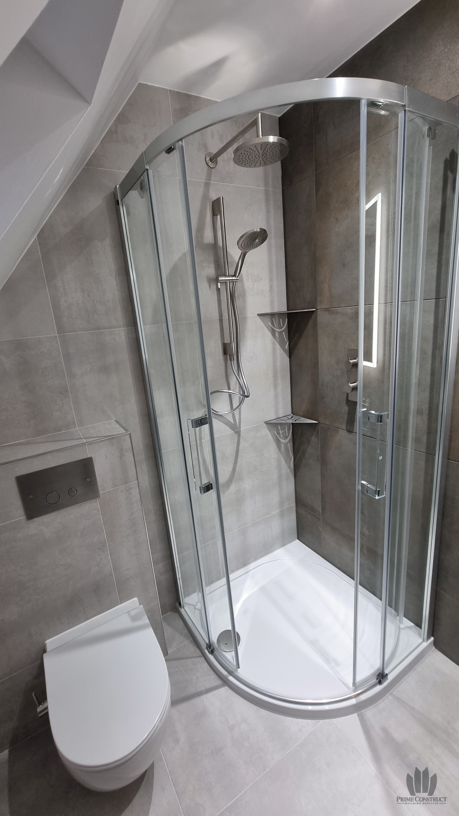 En suite curved shower enclosure and adjacent WC