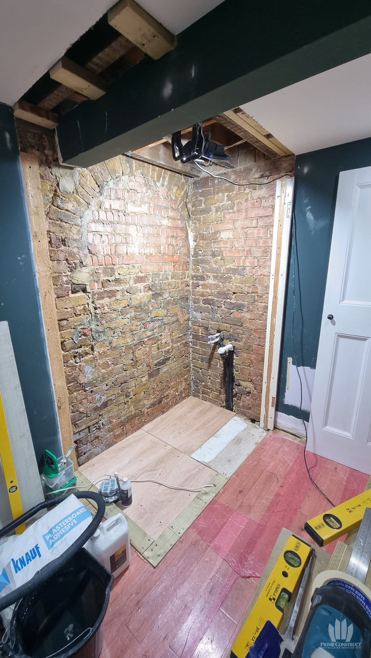 Opened bedroom corner with exposed brickwork and replacement floor panels