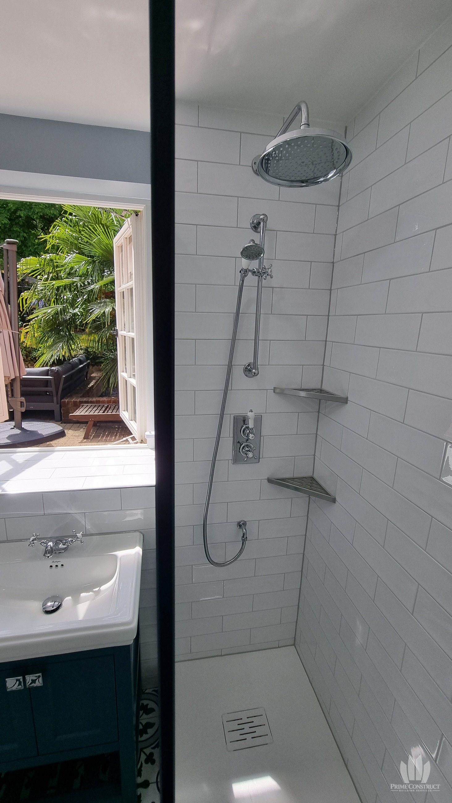 Glass shower, chrome fittings and white tiled walls