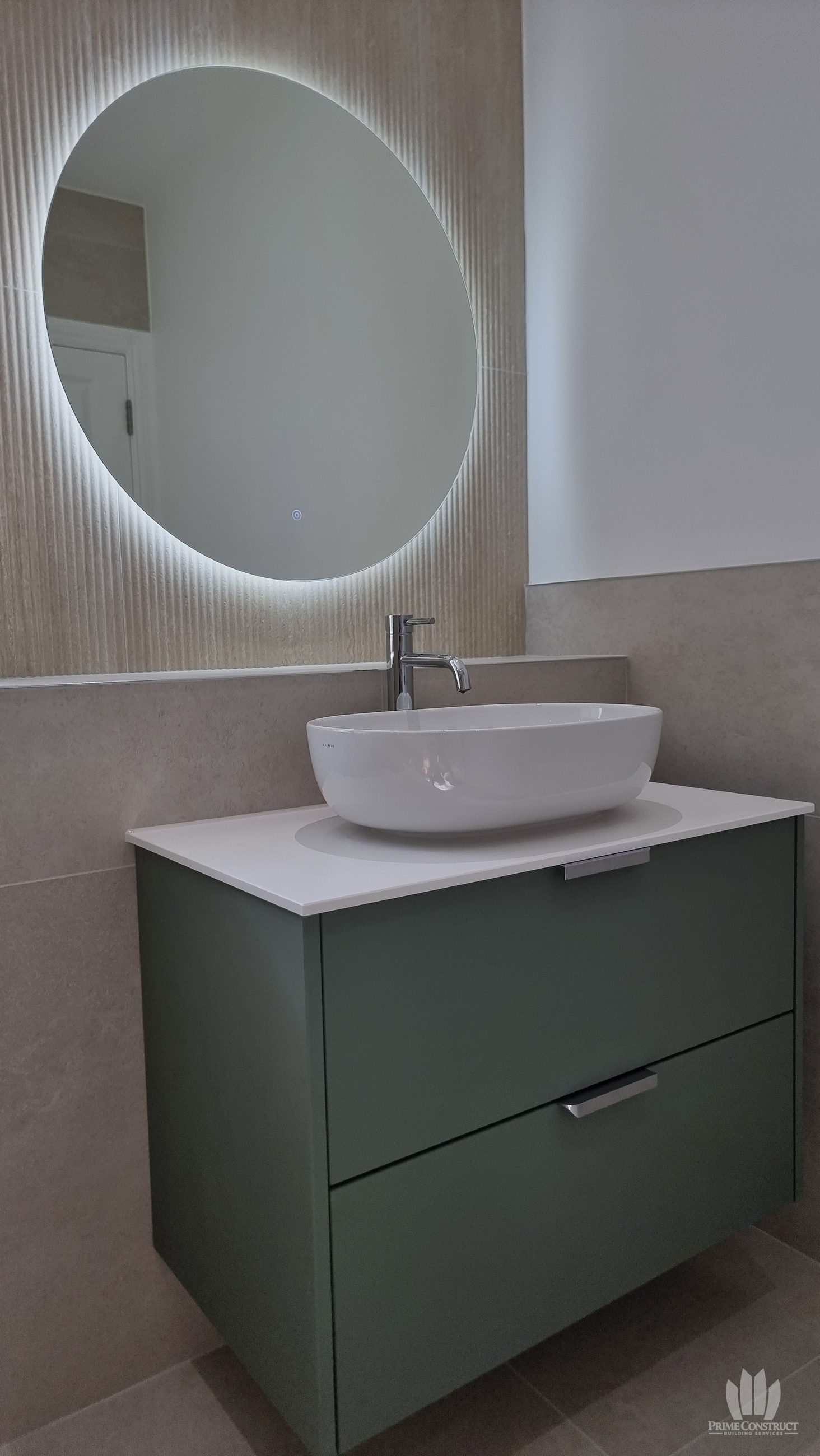 Closer green vanity, vessel basin and illuminated mirror detail.