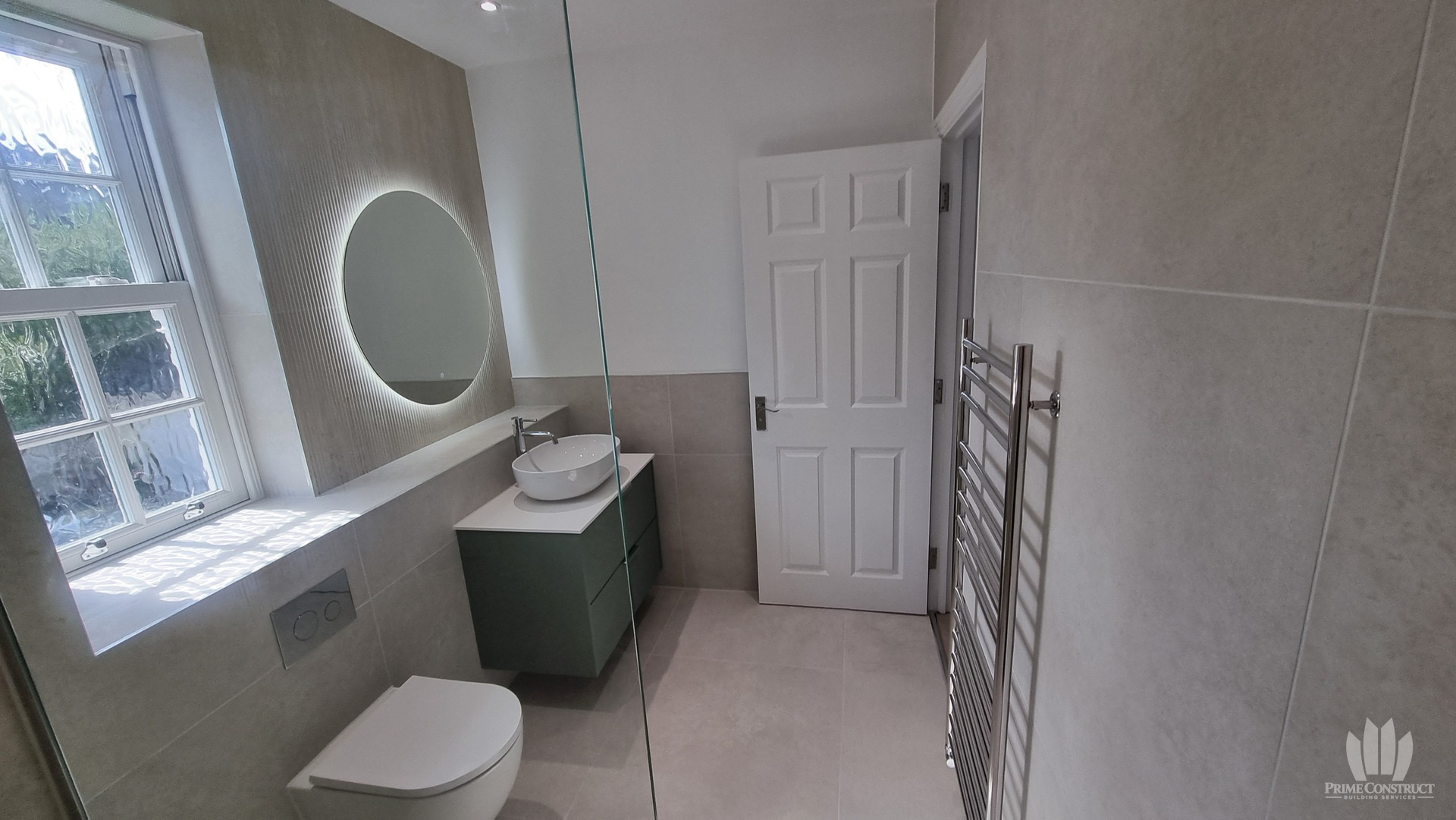 Reverse overview of WC, vanity, mirror and towel radiator.