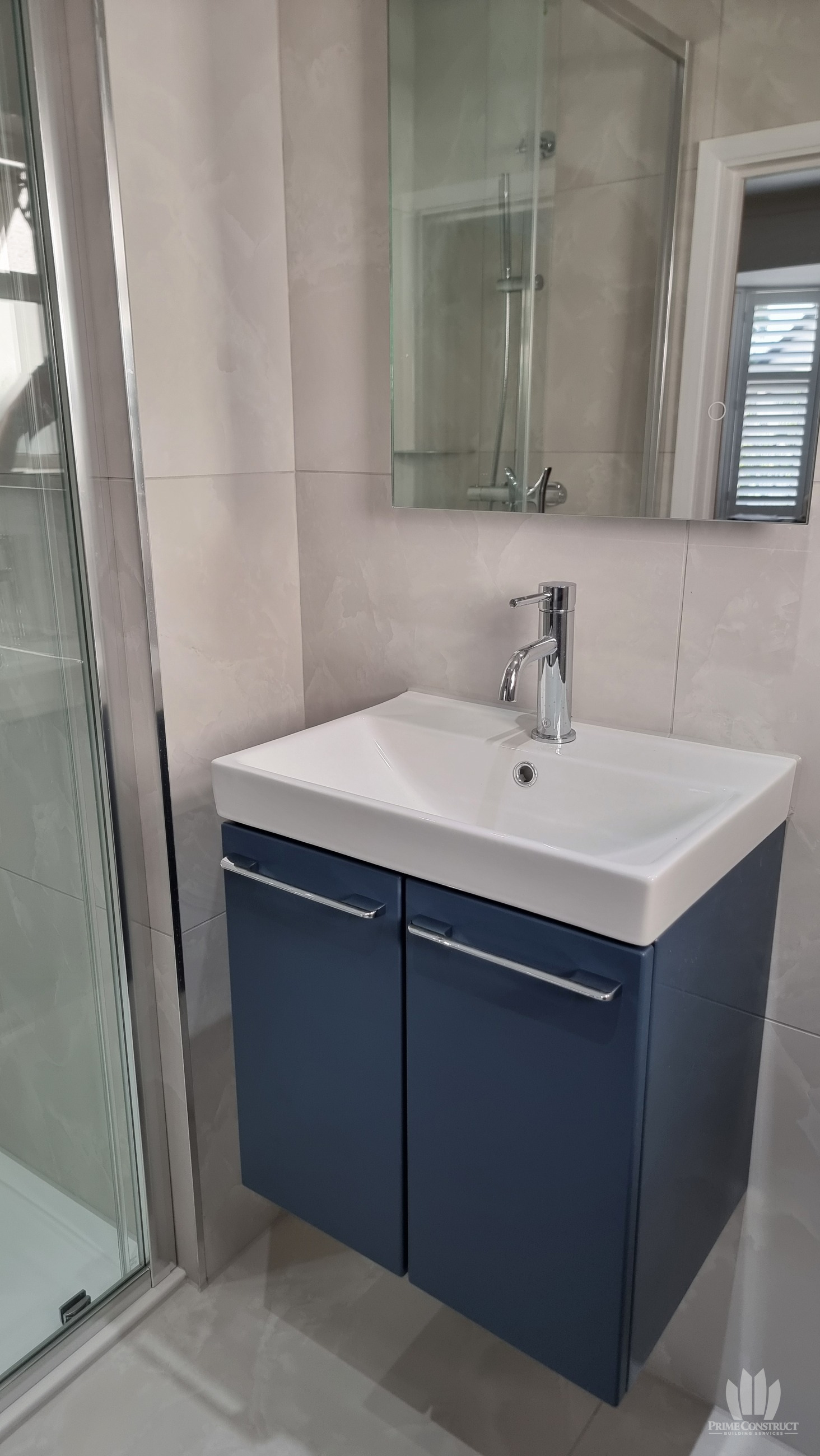 Dark blue wall-hung vanity, white basin and mirror
